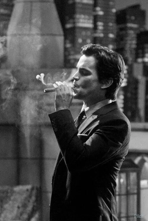 A guest in black tie lighting a cigar
